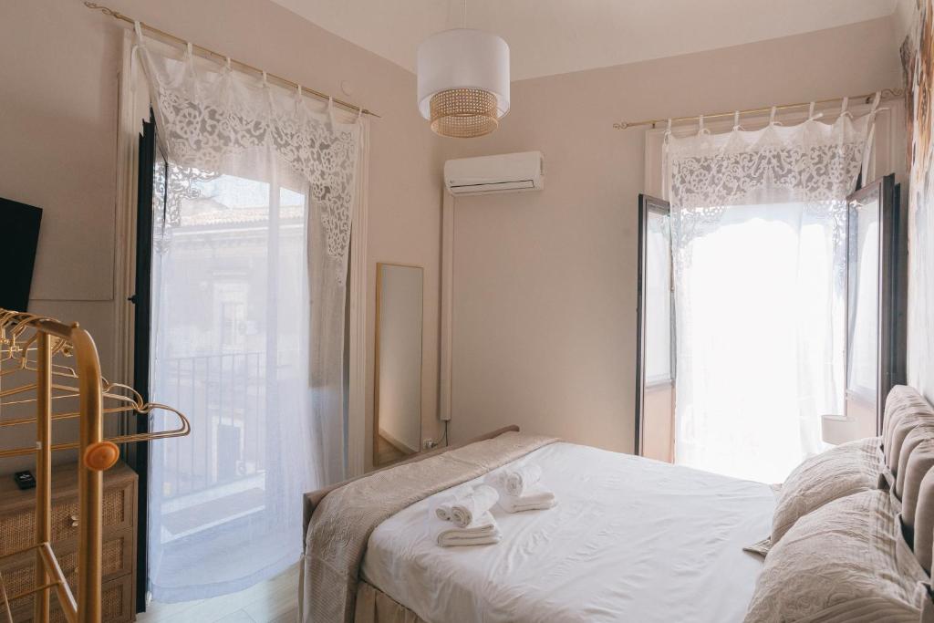 Camera da letto con doppia porta luminosa sul balcone, tende in tessuto di pregio e letto queen size.