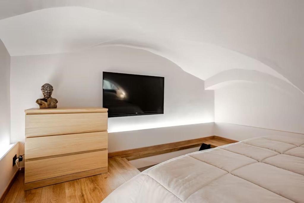 Vista della camera da letto, cassettiera e televisione.